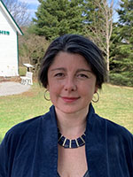 Image shows headshot of a woman against a natural backdrop.