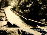 Image shows a black and white photo of the Hawk Lake Log Chute. 