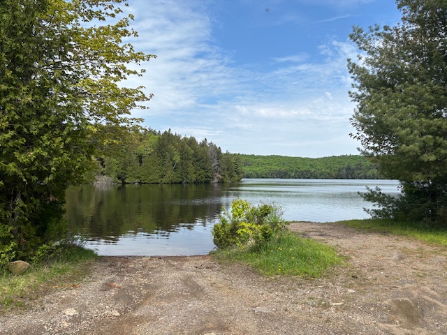 Image shows a boat launch with a lake in the background.