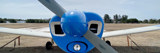 Image shows the front of a propeller plane. 