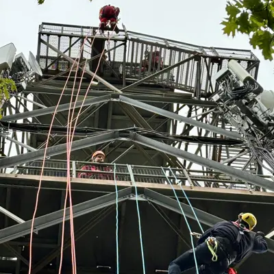 Image shows firefighters scaling the Dorset Tower with ropes. 