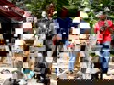 Image shows a group of people posing with a dog. 