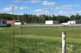 Image shows an airport with green grass and hangar buildings. 