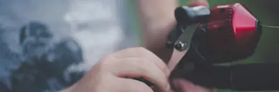Image shows a child's hands with a fishing pole. 