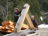 Image shows men working with large timbers. 