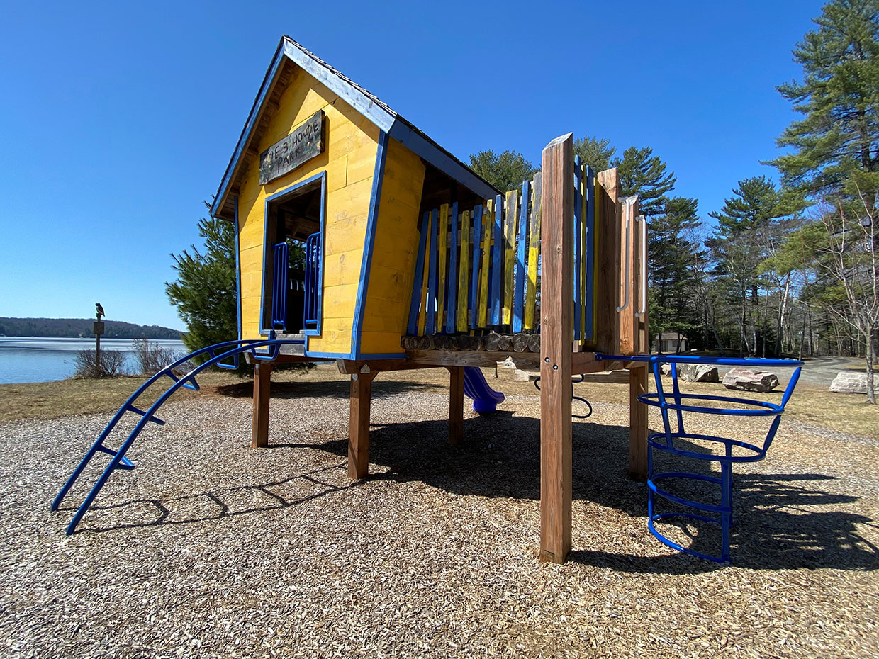 Image shows children's play equipment in the shape of of yellow treehouse.