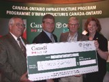 Image shows a group of people holding a large novelty cheque. 