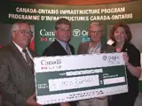 Image shows a group of people holding a large novelty cheque. 