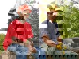 Image shows two men in hardhats taking a break. 