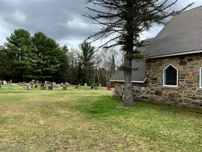Image shows a cemetery and stone church in autumn. 