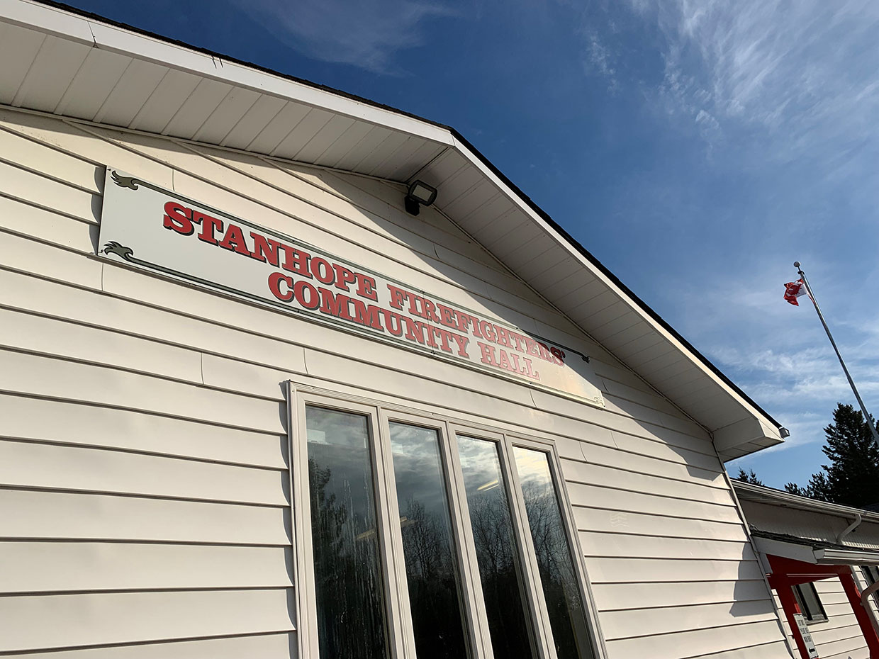 Image shows  white building with a sign reading Stanhope Firefighers' Community Haff.