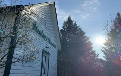 Image shows the Stanhope Heritage Museum with the sun in the background. 