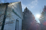 Image shows the Stanhope Heritage Museum with the sun in the background. 