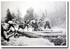 Image shows men guiding logs down a river using poles and spikes.
