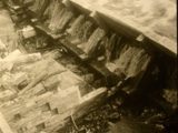 Image shows a black and white picture of the log chute with water flowing through it. 