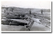 Image shows men floating on logs and posing for a picture.